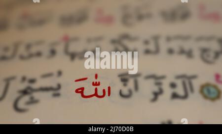 Arabic Allah texte dans la page ouverte de coran, macro-shot de Dieu islamique, l'idée de coran et le concept musulman, assis vue, sélectif foyer, gros plan Banque D'Images