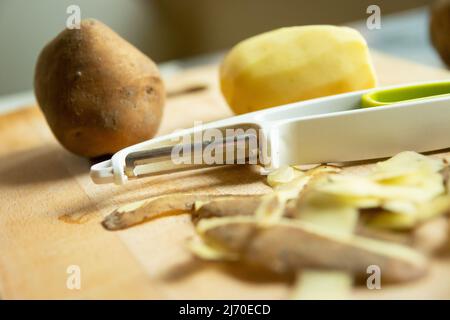 Épluchez et peler les pommes de terre avec des pelures sur la table Banque D'Images