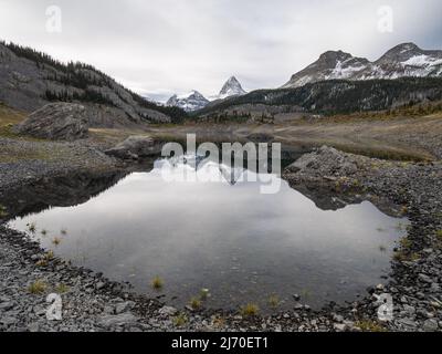 Pic proéminent se reflétant dans le lac alpin pendant la journée de fonte, Mt Assiniboine Pr. Parc, Canada Banque D'Images