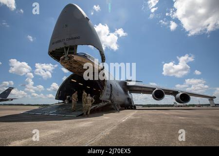 Les soldats de l'armée américaine de la 3rd Brigade de l'aviation de combat, 3rd Infantry Division, se rassemblent sur la rampe de chargement d'un C-5M Super Galaxy pour mener un entraînement de charge aérienne conjoint avec les aviateurs du 9th Escadron de transport aérien, 436th Escadre de transport aérien, à l'aérodrome de l'armée Hunter, en Géorgie, le 2 mai 2022. Cette formation est essentielle pour s'assurer que les forces conjointes sont prêtes à charger efficacement et en toute sécurité des équipements sur les avions Air Mobility Command, assurant ainsi une mobilité mondiale rapide et une projection de puissance de combat. (É.-U. Photo de l'armée par le Sgt. Savannah Roy/3rd Brigade de l'aviation de combat, 3rd Division d'infanterie) Banque D'Images