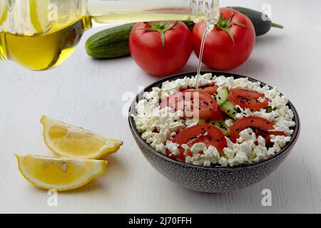 Vinaigrette à l'huile d'olive, salade de tomates fraîches, concombres, fromage cottage et cumin noir Banque D'Images