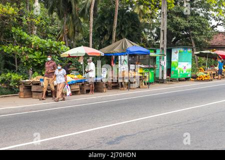 Malabe, Sri Lanka - 4 décembre 2021 : acheteurs et assistants au marché des fruits en bord de route dans la banlieue de Colombo Banque D'Images