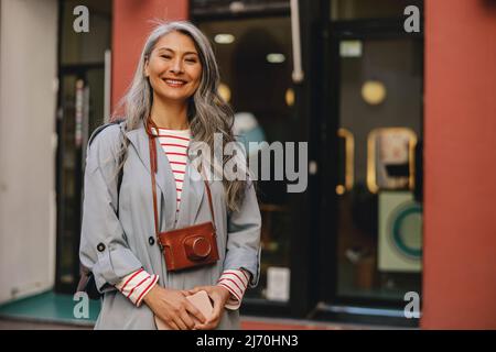 Femme confiante avec visage heureux posant à l'extérieur Banque D'Images