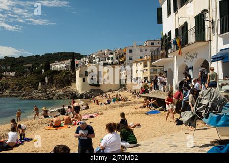 Calella de Palafrugell, Espagne - 25 avril 2022 : bateaux de pêche et touristes sur la plage de Port Bo, vieille ville de Calella de Palafrugell, sur la Costa Brava Banque D'Images