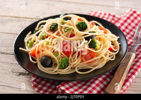 Spaghetti aux légumes (brocoli, tomates, poivrons) sur table en bois Banque D'Images
