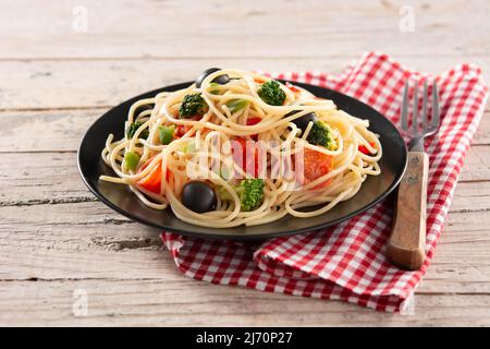 Spaghetti aux légumes (brocoli, tomates, poivrons) sur table en bois Banque D'Images