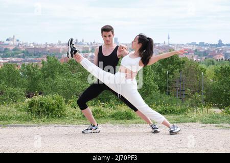 Jeune couple pratiquant la danse de rue, le ballet, les marches dansantes, les mouvements. Banque D'Images