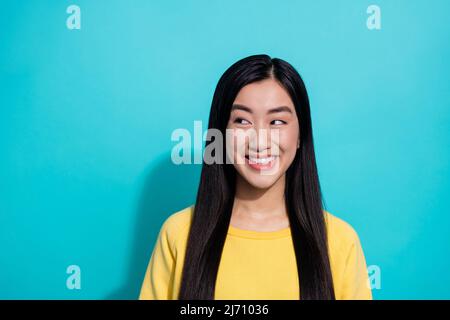 Photo de douce drôle dame vêtue jaune chandail aspect vide espace souriant isolé couleur turquoise arrière-plan Banque D'Images