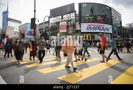 Des piétons portant un masque facial sont vus traverser la rue près d'un centre commercial pendant les vacances d'Eid al-Fitr à Kuala Lumpur. (Photo de Wong Fok Loy / SOPA Images/Sipa USA) Banque D'Images