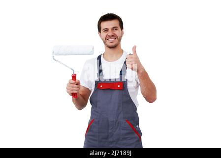 Portrait d'homme souriant en vêtements de travail tenant un rouleau de peinture isolé sur fond blanc, concept de rénovation Banque D'Images