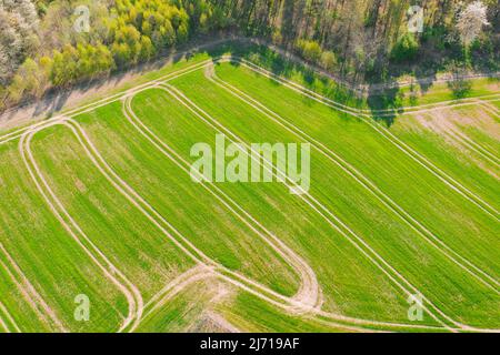 Une vaste plaine couverte de terres arables et de prairies. Vous pouvez voir des touffes d'arbres à certains endroits. Le ciel est légèrement nuageux. Photo du drone. Banque D'Images