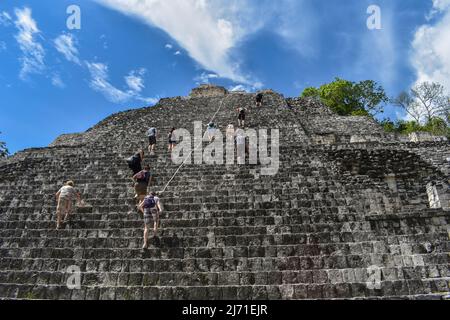 Un groupe de touristes escaladez une grande pyramide maya à Becán Banque D'Images