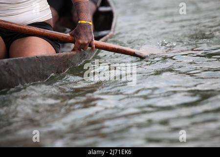 Détail d'une femme qui rame, voyage sur un canot en bois rudimentaire sur la rivière Xingu, Amazone, Brésil. 2010. Banque D'Images