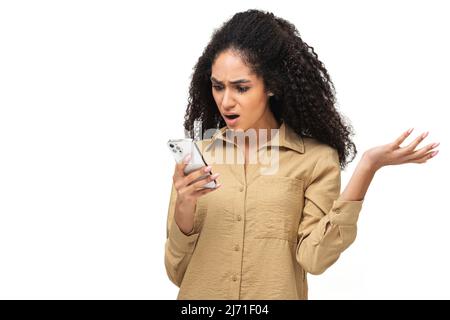Déçue jeune femme afro-américaine tenant un smartphone et regardant à l'écran du téléphone, dame a reçu une mauvaise notification ou des messages, se sent contrariée, haussant, isolée Banque D'Images