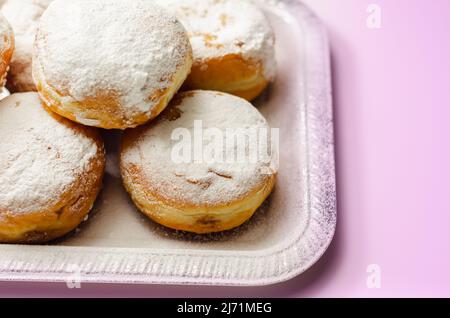 Berliner Pfannkuchen, un donut allemand, pâte traditionnelle de levure frite en profondeur remplie de crème au chocolat et saupoudrée de sucre en poudre, douceur sur un Banque D'Images