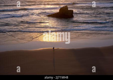 Surfer avec surf marche sur la plage, Sagres, Portugal, côte de l'Algarve, au coucher du soleil, vagues Banque D'Images