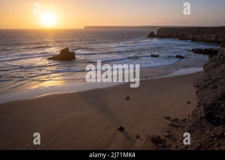 Surfer avec surf marche sur la plage, Sagres, Portugal, côte de l'Algarve, au coucher du soleil, vagues Banque D'Images