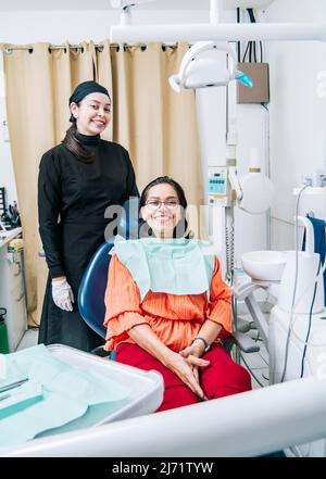 Dentiste avec le patient souriant à la caméra au bureau, dentiste satisfait et patient souriant à la caméra, dentiste satisfait et concept de patient Banque D'Images