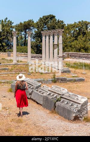 Jeune femme avec robe devant des ruines avec des colonnes, ancien temple, Asklepieion, Kos, Dodécanèse, Grèce Banque D'Images