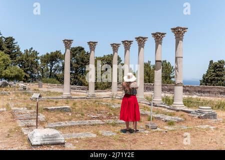 Jeune femme avec robe devant des ruines avec des colonnes, ancien temple, Asklepieion, Kos, Dodécanèse, Grèce Banque D'Images