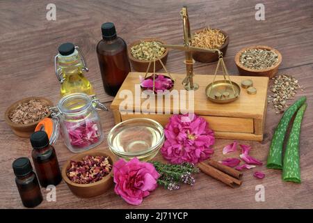 Préparation des herbes et des fleurs pour le traitement naturel de la peau à base de plantes avec des balances en laiton et des bouteilles d'huile essentielle. Traitement naturel de la médecine des plantes Banque D'Images