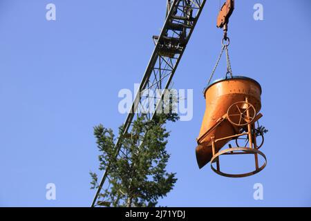 La flèche d'une grue de construction s'accroche au sommet d'un arbre Banque D'Images