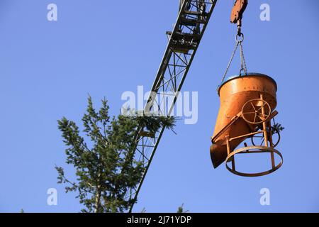 La flèche d'une grue de construction s'accroche au sommet d'un arbre Banque D'Images