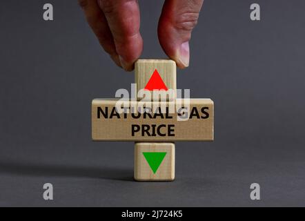 Symbole d'augmentation ou de diminution du prix du gaz naturel. Homme d'affaires détient un cube symbolisant le niveau des prix du gaz naturel. Magnifique fond gris. Busi Banque D'Images