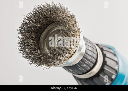 Perceuse à main avec brosse ronde en acier sur fond blanc Banque D'Images