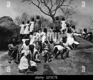 Les filles soudanaises train pour être enseignants. Ils apprennent dans les salles de classe de Grass Hut jusqu'à ce que le New College soit prêt. Reposant au sommet de la colline rocheuse, ce groupe de filles combine une géographie moins avec P.T. et écoute l'enseignante, Mlle Anne Gosling (au centre) soulignant les caractéristiques de la plaine ci-dessous. 14 mai 1953. (Photo du Bureau central d'information). Banque D'Images