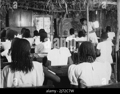 Les filles soudanaises s'entraîne pour être des enseignants : elles apprennent dans les salles de classe de Grass Hut jusqu'à ce que le nouvel ordre soit prêt - cette cabane à gazon sert de salle de classe temporaire pour les stagiaires enseignants pendant la construction de leur centre de formation ? Batoul Ibrahim, qui est un Capt d'Omdurman, enseigne ici aux filles l'effet des terres arides sur le climat dans la région des monts Nuba. 14 mai 1953. (Photo du Bureau central d'information). Banque D'Images