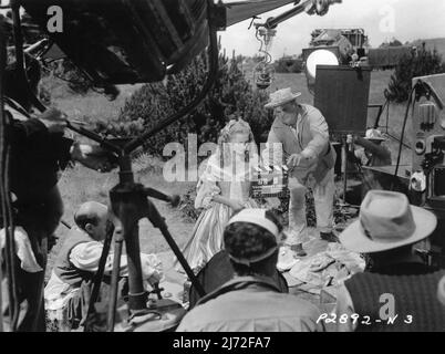 JOAN FONTAINE sur le terrain de tournage Candid avec Movie Crew pendant le tournage de FRENCHMAN'S CREEK 1944 réalisateur MITCHELL LEISEN roman Daphne du Maurier cinéaste George Barnes costume Raoul Pene du Bois musique Victor Young Paramount Pictures Banque D'Images