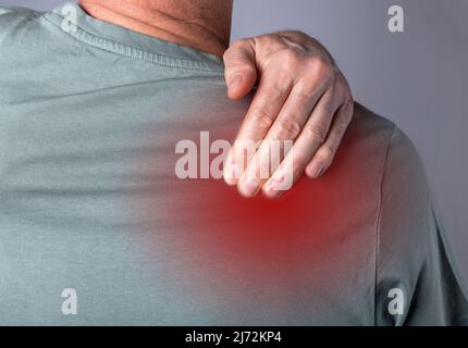 Gros plan sur la douleur à l'épaule. Corps souffrant de douleur dans le corps. Point rouge. Banque D'Images