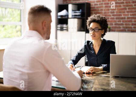 Femme Manager entretien d'un jeune candidat masculin au bureau Banque D'Images