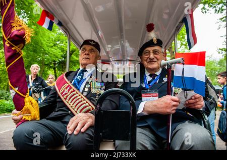 Deux anciens combattants britanniques de la Seconde Guerre mondiale attendent à l'arrière de l'un des véhicules pendant le défilé de la Journée de la libération. Wageningen, également connue sous le nom de « ville de libération », est liée aux jours de commémoration et de libération des 4th et 5th mai, car la capitulation qui a mis fin à la Seconde Guerre mondiale aux pays-Bas a été signée à l'Hôtel de Wereld de la ville en 1945. Pendant la journée de la libération, la parade de la libération ou le Bevrijdingsdefilé, en tant que vétérans et successeurs militaires néerlandais, se réunissent pour rendre hommage à tous ceux qui ont donné leur vie pendant la Seconde Guerre mondiale. Cette année aussi, 25 anciens combattants britanniques ont été chaleureusement accueillis, le Banque D'Images