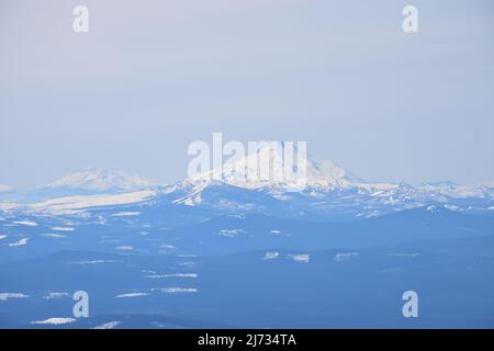 De droite à gauche, les sommets du Mont Jefferson et les montagnes Three Sisters vus du côté sud du Mont Hood, la plus haute montagne de l'Oregon, en avril 2022 Banque D'Images