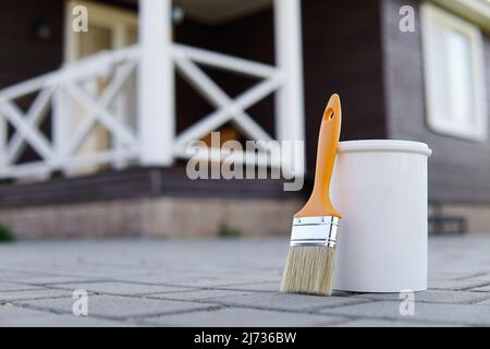 Peinture et pinceau blancs. Terrasse peinte en arrière-plan. Banque D'Images