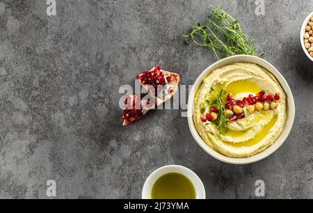 Houmous libanais, purée de pois chiches avec grenade, citron vert, épices, huile d'olive et herbes. Recette maison, en-cas sain.Vue de dessus, espace de copie. Banque D'Images