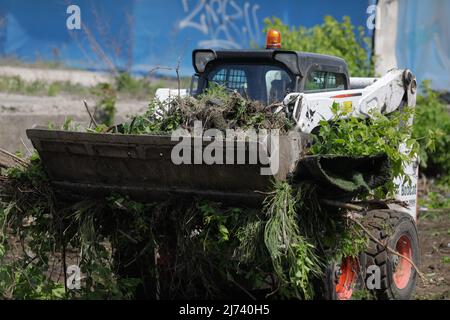 Bucarest, Roumanie - 1 mai 2022 : les travailleurs nettoient une zone de la végétation et des débris de chemin de fer pour les travaux futurs. Banque D'Images