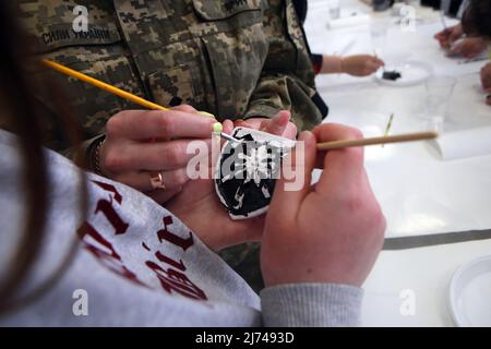 Non exclusif: MUKACHEVO, UKRAINE - 5 MAI 2022 - Une fille teinte un médaillon avec le chevron de l'assaut de montagne séparé de 128th pendant un mas Banque D'Images