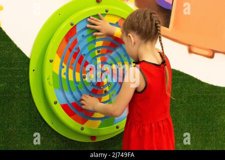 Enfant jouant avec labirint en bois dans le centre de jeu à l'intérieur Banque D'Images