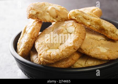 Biscuits aux pépites de chocolat blanc maison avec noix de macadamia sur la table en gros plan. Horizontale Banque D'Images