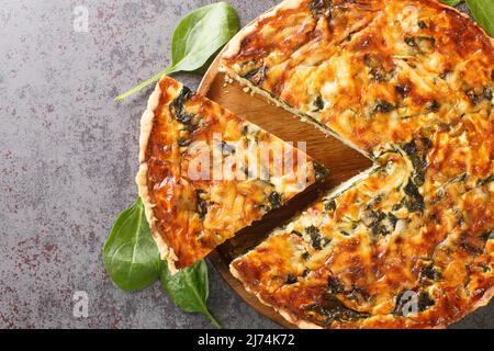 Quiche florentine aux épinards, fromage, œufs et épices sur table grise avec spatule, gros plan. Vue de dessus du dessus du hoizontal Banque D'Images