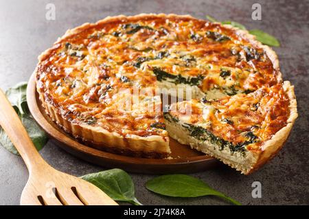 Quiche florentine aux épinards, fromage, œufs et épices sur table grise avec spatule, gros plan. Hoizontal Banque D'Images