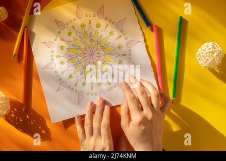 Page de coloriage antistress pour femme. Femme peinture main mandala. Femme peinture mandalas pour combattre le stress. Détente passe-temps bien-être mental et art thérapie. Femme peint le dessin, processus méditatif de colorier les pages. Expression de soi par l'art Banque D'Images