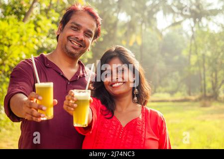 bonne famille indienne tenant un verre de jus de canne frais avec tube en métal écologique. Amour à la santé et sauver la planète . concept recyclable Banque D'Images