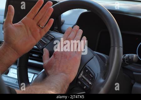 Gros plan des mains du conducteur en roquant l'avertisseur sonore Banque D'Images