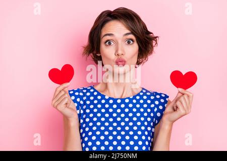Photo de la jolie jeune femme brune tient coeur Blow baiser porter blouse bleue isolée sur fond rose couleur Banque D'Images