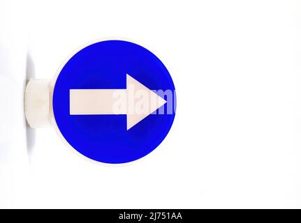 Panneau de signalisation avec une flèche blanche sur fond bleu indiquant une direction obligatoire vers la droite Banque D'Images