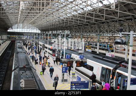 Vue des trains sur les quais de la gare de Manchester Piccadilly le 5th mai 2022 avec des passagers sur les quais de départ et d'embarquement des trains. Banque D'Images